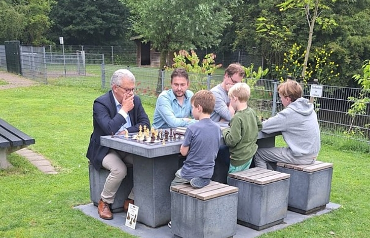 Foto van schakers aan nieuwe schaak- en damtafel in de Houtkamp